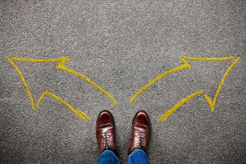 Decision in Life or Business Concept. Separates the Left and Right by two Arrow Direction. Top View of a Young Man with Brown Wingtips Shoes and Jeans Standing on the Grunge Floor