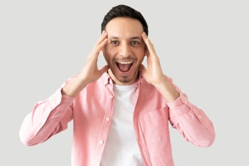 Good looking young man looking surprised and screaming with excitement in a studio