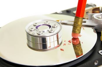 A pencil eraser erasing on a computer hard drive