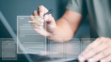 A person's hand is holding a stylus and reaches forward to a virtual screen to select a specific virtual document.