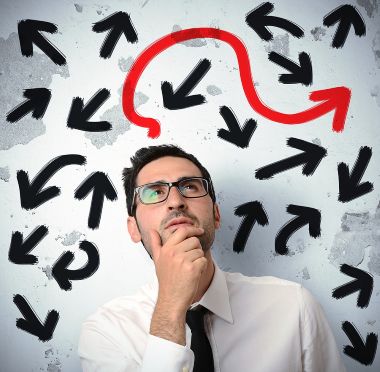 Confused businessman is surrounded by multi-directional arrows and is pondering the correct way.